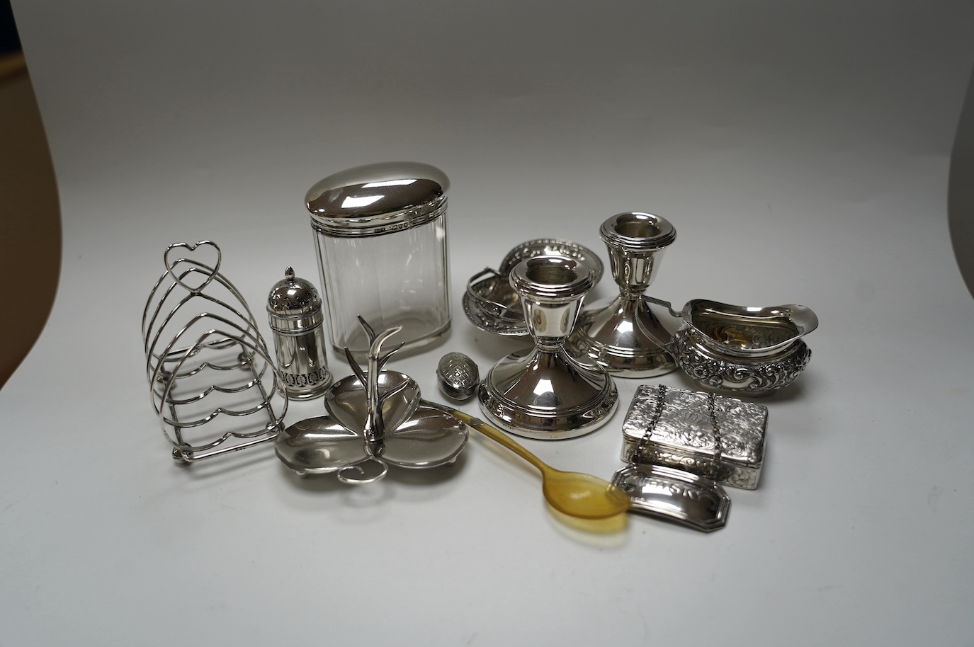 A group of mixed silver including a five bar toastrack, pair of dwarf candlesticks, 19th century snuff box, ring tree dish, cream jug, etc. Condition - poor to fair